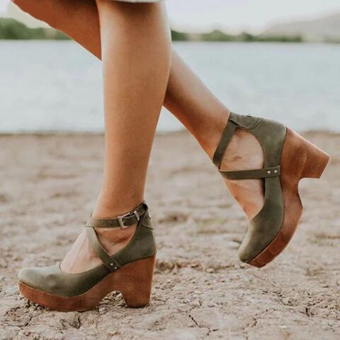 Grüne Damen-Clogs mit Holzabsatz am Strand. Modische, bequeme Schuhe für Sommer und Freizeit. Perfekt für stilvolle Outfits und Strandspaziergänge.