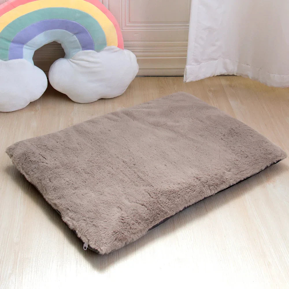 Braunes Hundebett aus Plüsch, rechteckig, auf Holzboden, neben Regenbogenkissen.