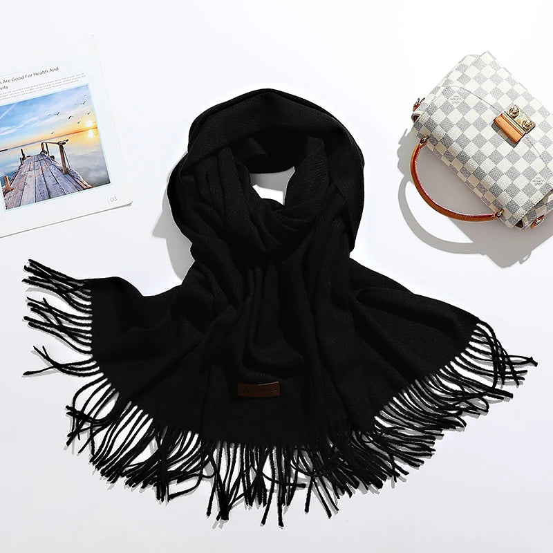Schwarzer Schal mit Fransen aus weichem Material, ideal für Herbst und Winter. Modisches Accessoire, vielseitig kombinierbar, zeitloses Design.