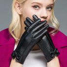 Elegante schwarze Lederhandschuhe mit Schleifen, ideal für Damenmode. Perfekt für Herbst und Winter, stilvoll und funktional.