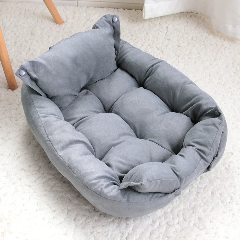 Graues Hundebett aus Stoff, weich gepolstert, ideal für kleine Haustiere, auf Teppichboden.