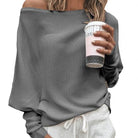 Damenpullover in Grau, schulterfrei, kombiniert mit bequemer Jogginghose. Perfekt für lässige Outfits und gemütliche Herbsttage.