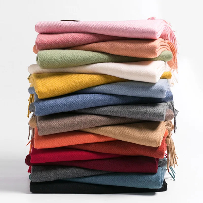 Ein Stapel bunter Kaschmirschals in verschiedenen Farben, ideal für Herbst und Winter. Weiche, luxuriöse Schals für stilvolle Wärme.