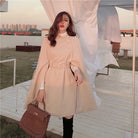 Eleganter Damenmantel in Beige mit Gürtel, ideal für Herbstmode. Stilvoller Look, perfekt für urbane Outfits. Hochwertige Materialien.
