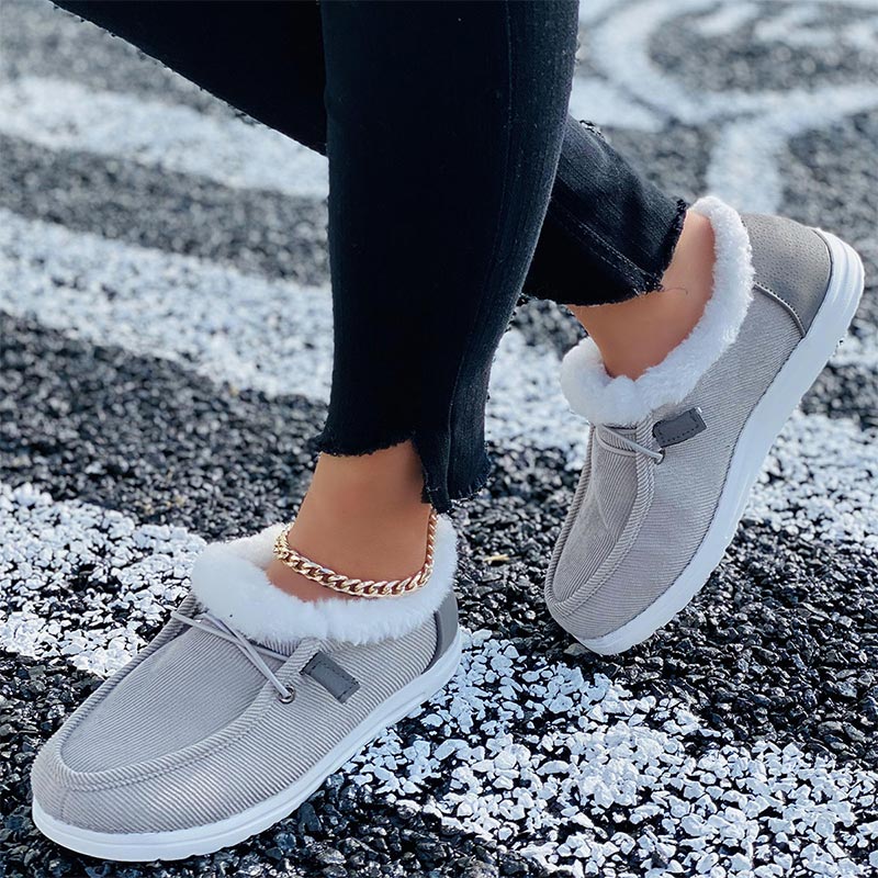 Damen-Sneaker mit weißem Kunstfell, grauem Stoff und weißer Sohle. Bequeme, modische Schuhe für Herbst und Winter. Ideal für Freizeitoutfits.