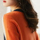Frau in orangefarbenem Pullover, stilvolles Herbstoutfit, weiches Strickmaterial, modische Damenbekleidung, trendige Herbstmode.