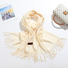 Eleganter cremefarbener Schal mit Fransen, ideal für Herbst und Winter. Weiches Material, modisches Accessoire, perfekt für stilvolle Outfits.