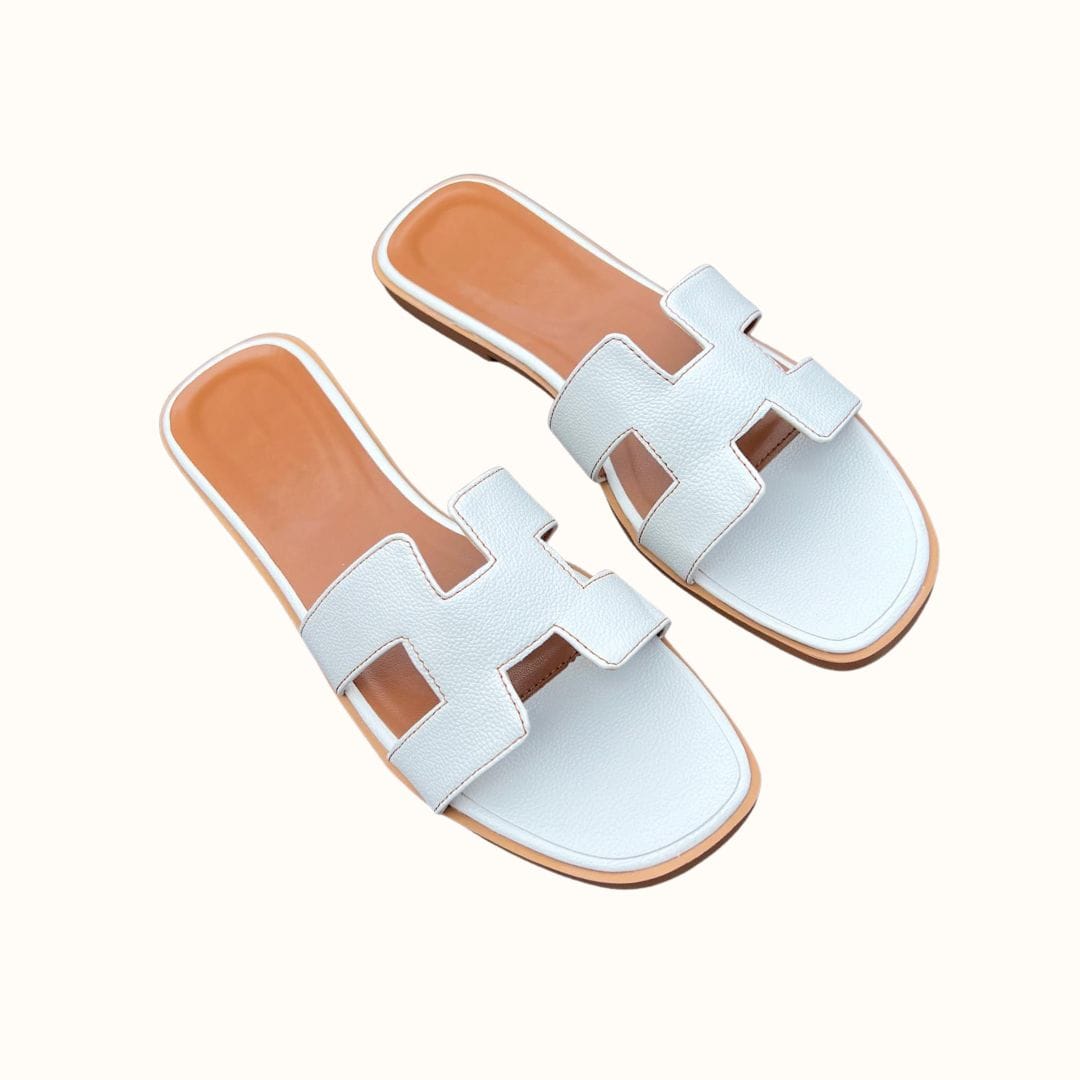 Weiße Ledersandalen mit offenem Zehenbereich und flachem Absatz. Stilvolle Sommerschuhe für Damen, ideal für Freizeit und Strand.