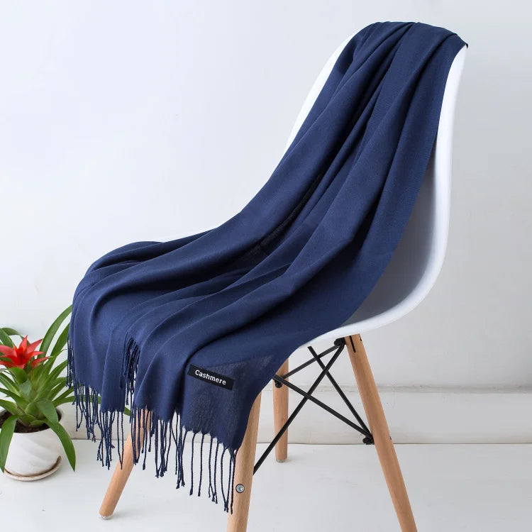Luxuriöser blauer Kaschmirschal auf modernem Stuhl, weiches Material, stilvolles Design, ideal für Herbst und Winter, modisches Accessoire.