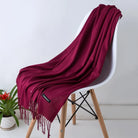 Eleganter roter Schal aus Kaschmir auf weißem Stuhl, ideal für Herbstmode. Weicher Stoff, stilvolles Design, perfektes Accessoire für Damen.