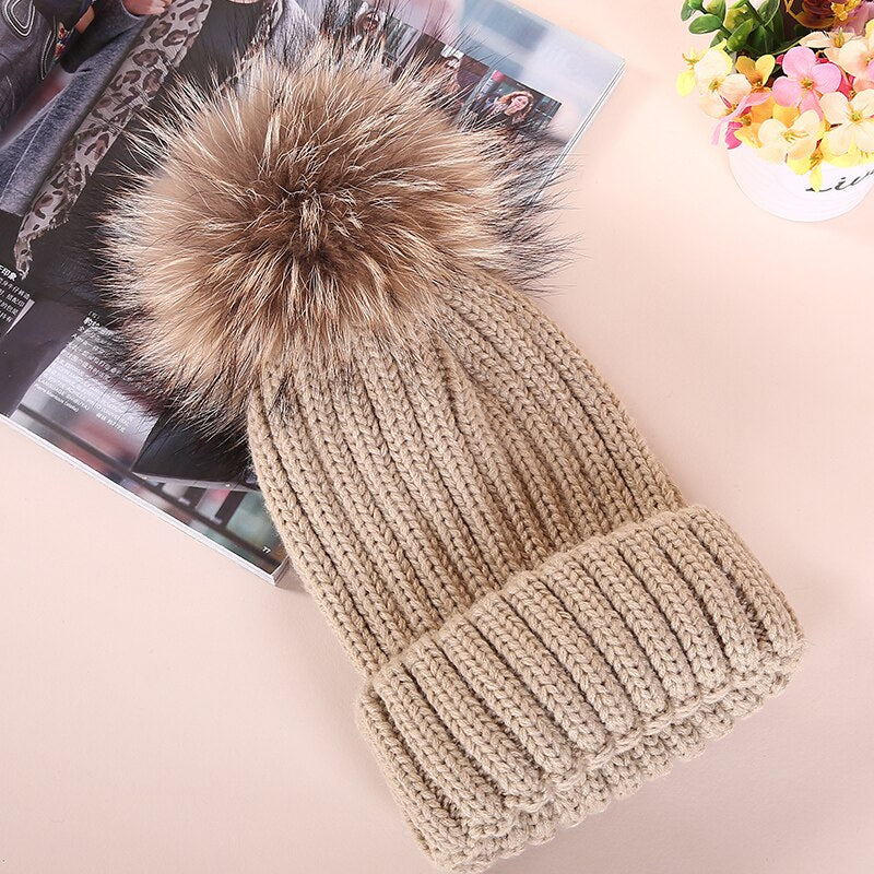 Beige Strickmütze mit Kunstfellbommel, modisch und warm, ideal für Wintermode. Perfekt für Damen, die stilvolle Accessoires suchen.