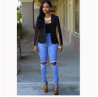 Frau in modischer Kleidung: Schwarzer Blazer, zerrissene blaue Jeans, Leoparden-High-Heels. Trendige Damenmode, urbaner Stil, Streetwear.