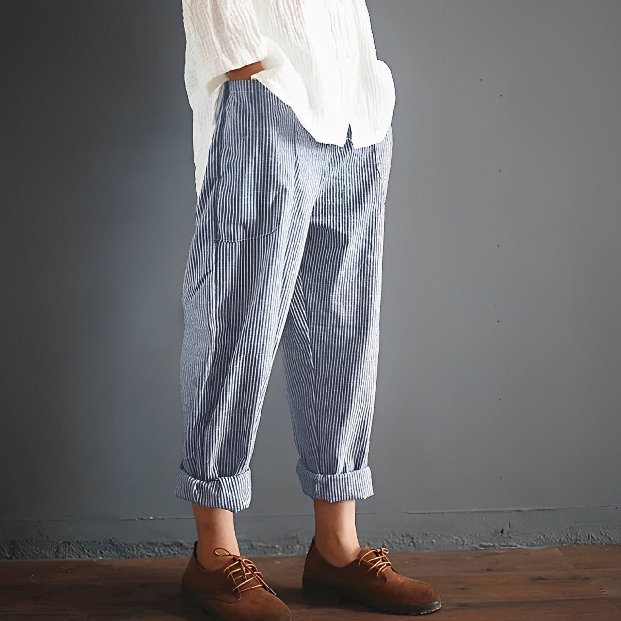 Gestreifte Damenhose, lässig geschnitten, kombiniert mit weißer Bluse und braunen Lederschuhen. Perfekt für modische Freizeitoutfits.