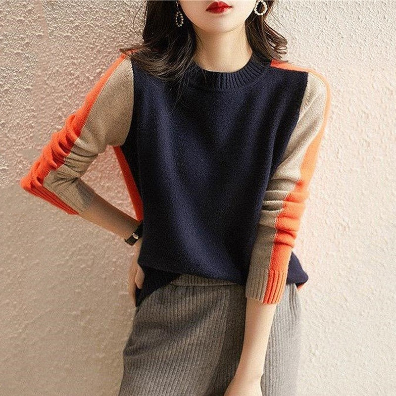 Damenpullover in Blau mit orangefarbenen und beigen Ärmeln, modisch und elegant. Perfekt für Herbstmode und stilvolle Outfits.
