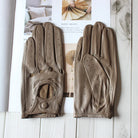Elegante braune Lederhandschuhe mit perforiertem Design auf einem Magazin. Perfekt für stilvolle Mode und Komfort. Hochwertige Accessoires.