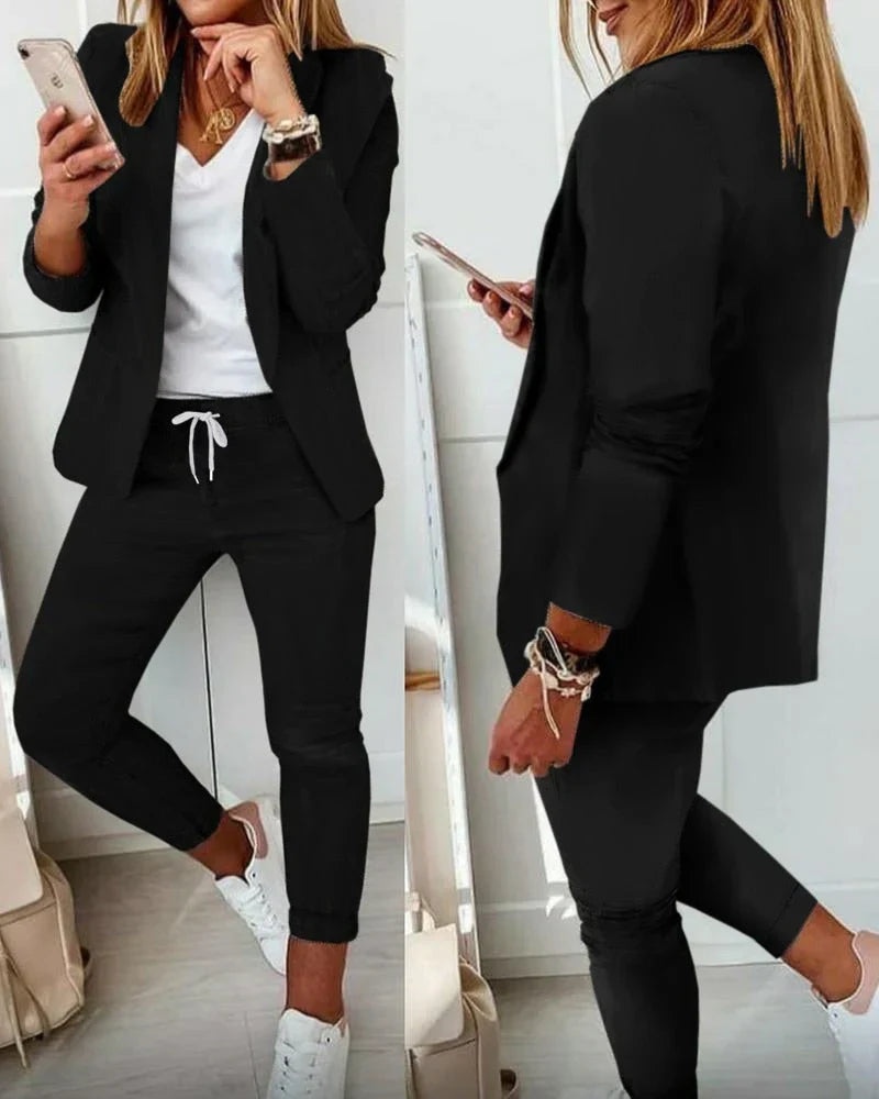 Damenanzug in Schwarz, lässig-elegant mit Blazer und Jogginghose, ideal für Business-Casual-Looks. Perfekt kombiniert mit weißen Sneakern.