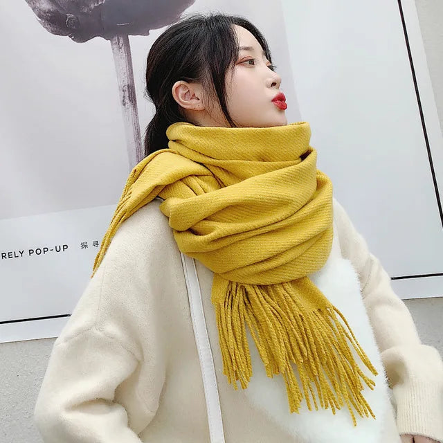 Frau mit gelbem Schal und weißem Pullover, stilvolles Winteroutfit, modische Accessoires, warme Bekleidung, trendige Damenmode.
