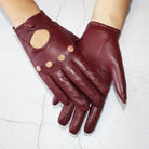 Damenhandschuhe aus weichem, burgunderrotem Leder mit stilvollen Cut-Outs und Knopfverschluss. Perfekt für Herbstmode und elegante Outfits.