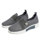 Graue Damen-Sneaker mit Klettverschluss, atmungsaktivem Mesh-Obermaterial und rutschfester Sohle. Ideal für Komfort und verbesserte Laufhaltung.