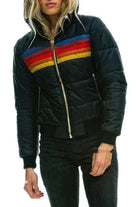 Damen Plüschmantel mit Kapuze, gesteppt, schwarz, bunte Streifen, Reißverschluss. Modische Winterjacke, warm und stilvoll für kalte Tage.