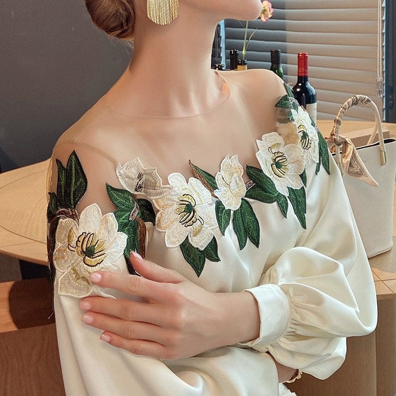 Elegantes Damenkleid mit floraler Stickerei, transparentem Ausschnitt und langen Ärmeln. Perfekt für besondere Anlässe und stilvolle Auftritte.