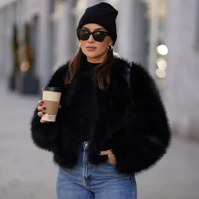 Damenmode 2023: Schwarzer Kunstpelzmantel, kombiniert mit Jeans und Mütze. Trendige Wintermode, Streetstyle, luxuriös und stilvoll.