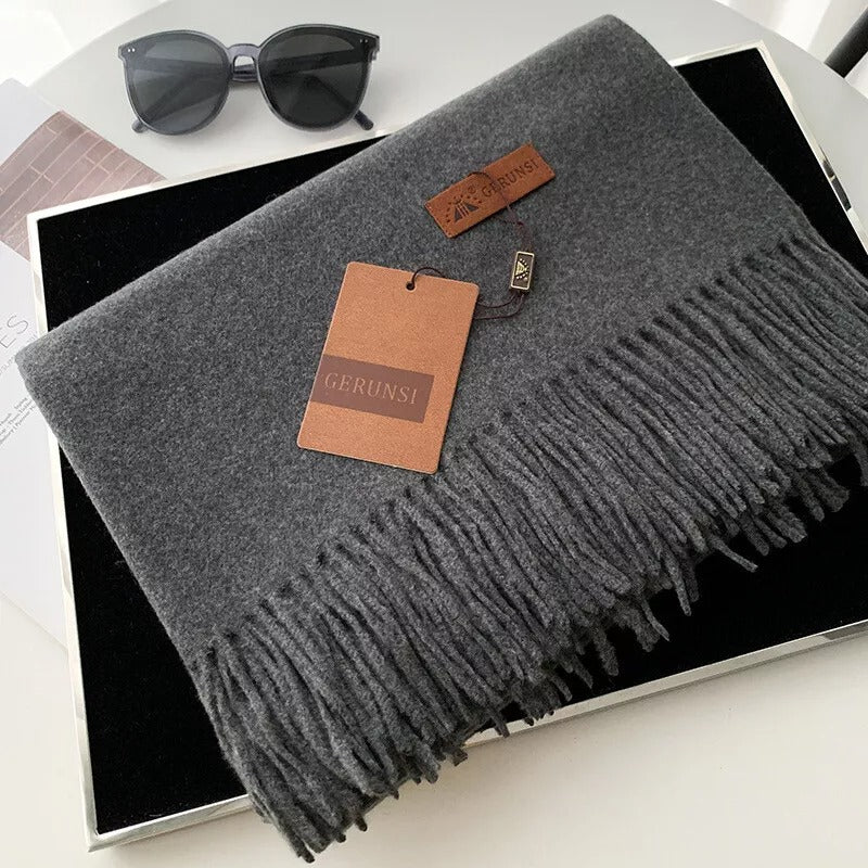 Grauer Schal mit Fransen, stilvoll und warm, ideal für Herbst und Winter. Hochwertige Materialien, perfekt als modisches Accessoire.
