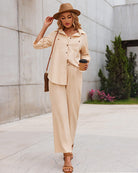 Damenoutfit in Khaki: Elegante Bluse und Hose, kombiniert mit Hut und Sandalen. Perfekt für stilvolle Freizeitmode und Sommertrends.