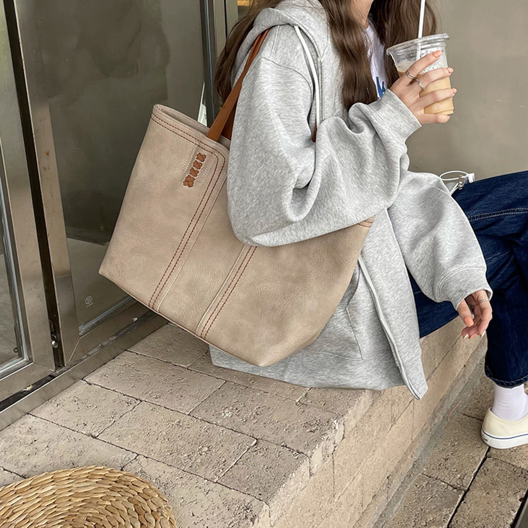 Damenhandtasche aus beigem Leder, lässig und geräumig, ideal für den Alltag. Perfekt kombiniert mit Freizeitkleidung und Accessoires.