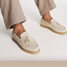 Elegante Herren-Slipper aus beigem Wildleder mit Quasten, kombiniert mit gestreiften Hosen. Perfekt für stilvolle, lässige Outfits.