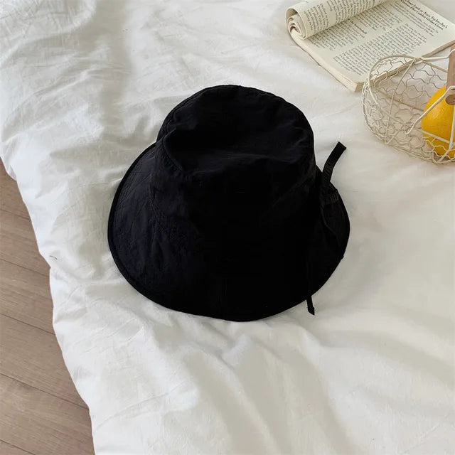 Schwarzer Fischerhut mit Kordelzug, ideal für Damen. Leicht, winddicht, perfekter Sonnenschutz. Trendiges Accessoire für Blogger und Modefans.
