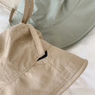Beige und grüner Fischerhut mit Kordelzug, ideal für Damen. Leicht, winddicht, Sonnenschutz. Perfekt für Outdoor-Aktivitäten und Reisen.