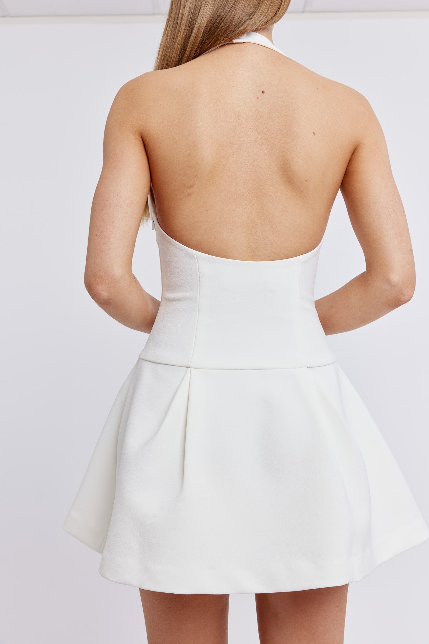 Weißes, rückenfreies Kleid für Damen, elegantes Design, ärmellos, ideal für Sommermode und besondere Anlässe, modischer Look.