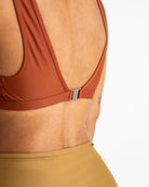 Frau in braunem Bikini-Oberteil, Rückansicht, elegantes Design, Sommermode, nachhaltige Bademode.