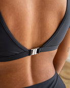 Frau in schwarzem Bikini-Oberteil, Rückenansicht, elegantes Design, Sommermode.