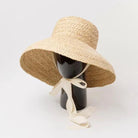 Breiter Strohhut für Damen, ideal für Sommer und Strand. Raffia-Material, flache Krone, UV-Schutz, modisches Accessoire für Urlaub.