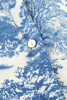 Blau-weißes Hemd mit Baumdruck, Nahaufnahme. Hochwertiger Baumwollstoff, elegantes Design, ideal für stilvolle Freizeitmode.