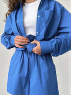 Frau in blauem Hemd und Shorts, modisch und lässig. Perfekt für Sommermode, Freizeitkleidung, Damenoutfit, trendige Styles.