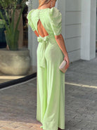 Elegantes, hellgrünes Jumpsuit mit Rückenausschnitt und Puffärmeln, ideal für Sommermode. Perfekt für stilvolle Anlässe und trendige Outfits.