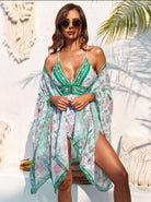 Frau im stilvollen, floralen Strandkleid mit Sonnenbrille, ideal für Sommermode und Strandurlaub. Perfekt für trendige Strandoutfits und Freizeitmode.