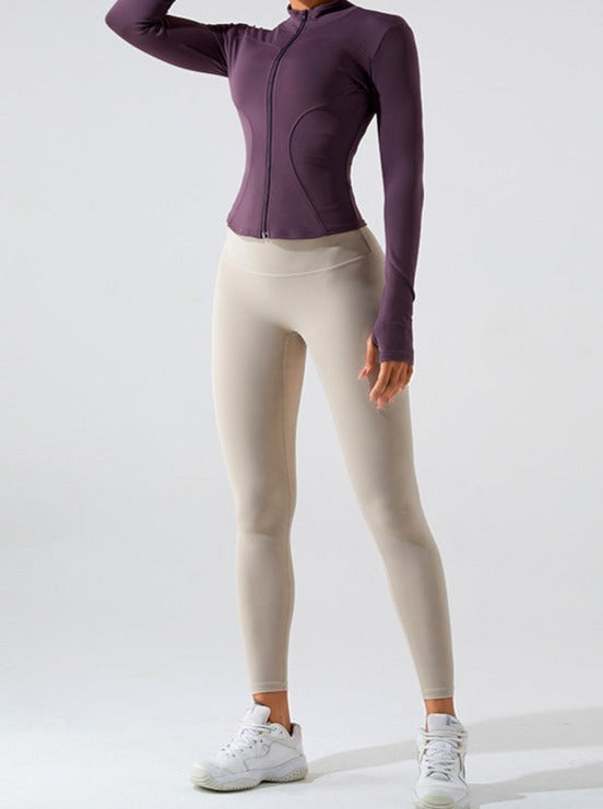 Damen-Sportbekleidung: Lila Trainingsjacke und beige Leggings, ideal für Fitness und Yoga. Bequeme, atmungsaktive Materialien für aktive Frauen.