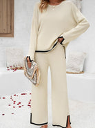 Elegantes cremefarbenes Damen-Outfit mit schwarzem Saum, bestehend aus Pullover und Hose. Perfekt für stilvolle Freizeit- und Büro-Looks.