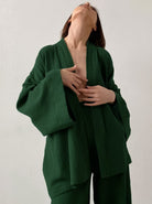 Frau in grünem Kimono-Set aus Baumwolle, minimalistisch, elegant, Mode, nachhaltige Kleidung, Damenbekleidung, zeitloses Design, Komfort.