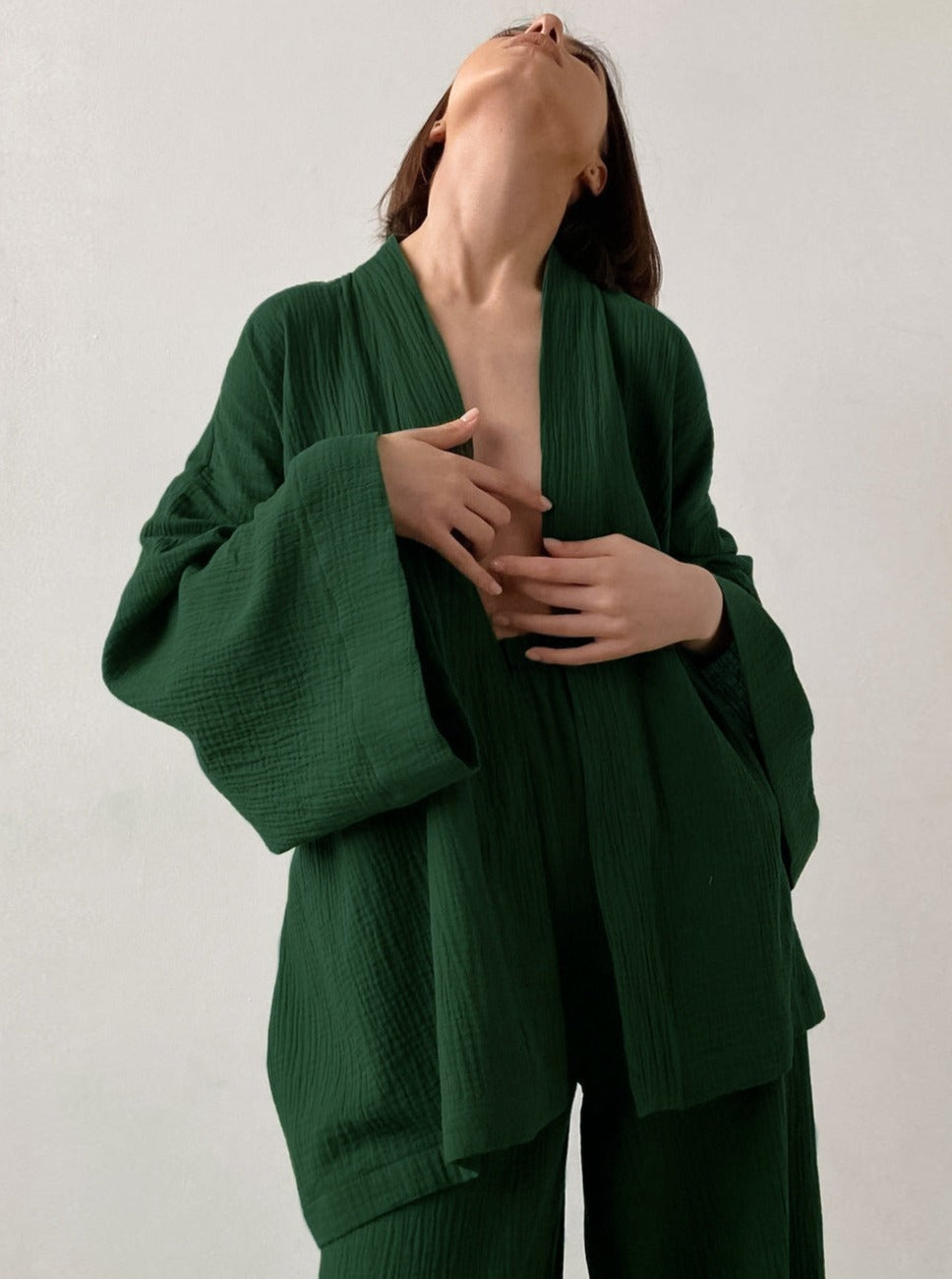 Frau in grünem Kimono-Set aus Baumwolle, minimalistisch, elegant, Mode, nachhaltige Kleidung, Damenbekleidung, zeitloses Design, Komfort.