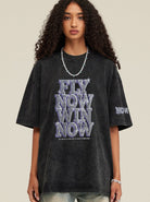Schwarzes Oversize-T-Shirt mit "Fly Now Win Now"-Aufdruck, lässiger Streetwear-Stil, ideal für trendige Mode und urbanen Look.