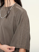 Damen T-Shirt in Khaki mit kurzen Ärmeln und Streifenmuster, kombiniert mit einer silbernen Kette. Perfekt für lässige Mode und Streetwear.