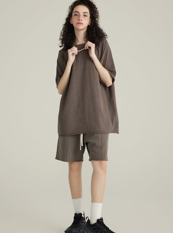 Frau in übergroßem braunem T-Shirt und Shorts, lässiger Look, Mode für Damen, bequeme Freizeitkleidung, trendige Streetwear, Sneakers.