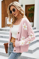 Damenmode: Rosa Strickjacke mit Blumenmuster, kombiniert mit weißem Top und Jeans. Trendige Sonnenbrille, lässiger Streetstyle-Look.