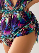 Bunter Badeanzug mit tropischem Blattmuster, V-Ausschnitt und seitlicher Raffung. Perfekt für Strandmode und Sommertrends.