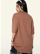 Frau in braunem Oversize-T-Shirt, lässiger Streetwear-Stil, modische Freizeitkleidung, ideal für trendige Outfits und urbanen Look.